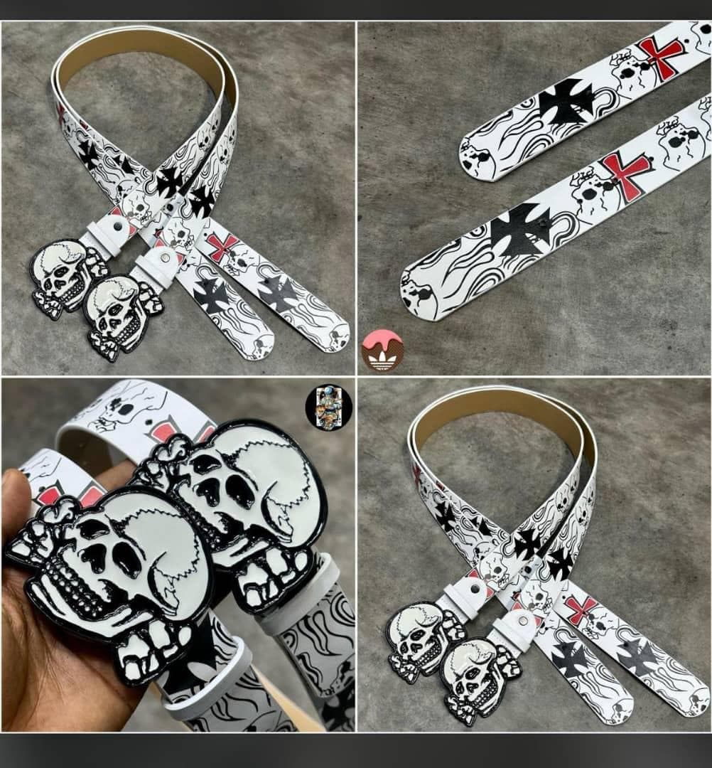 White skull and cross printed belt with large skull buckle shown in multiple views including on hand.