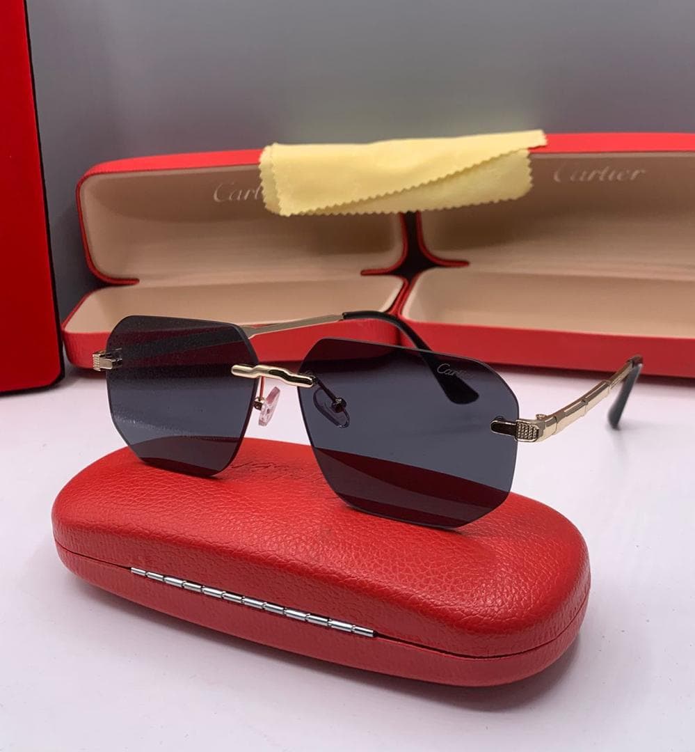 Cartier square sunglasses with dark lenses and gold black frame on red case.