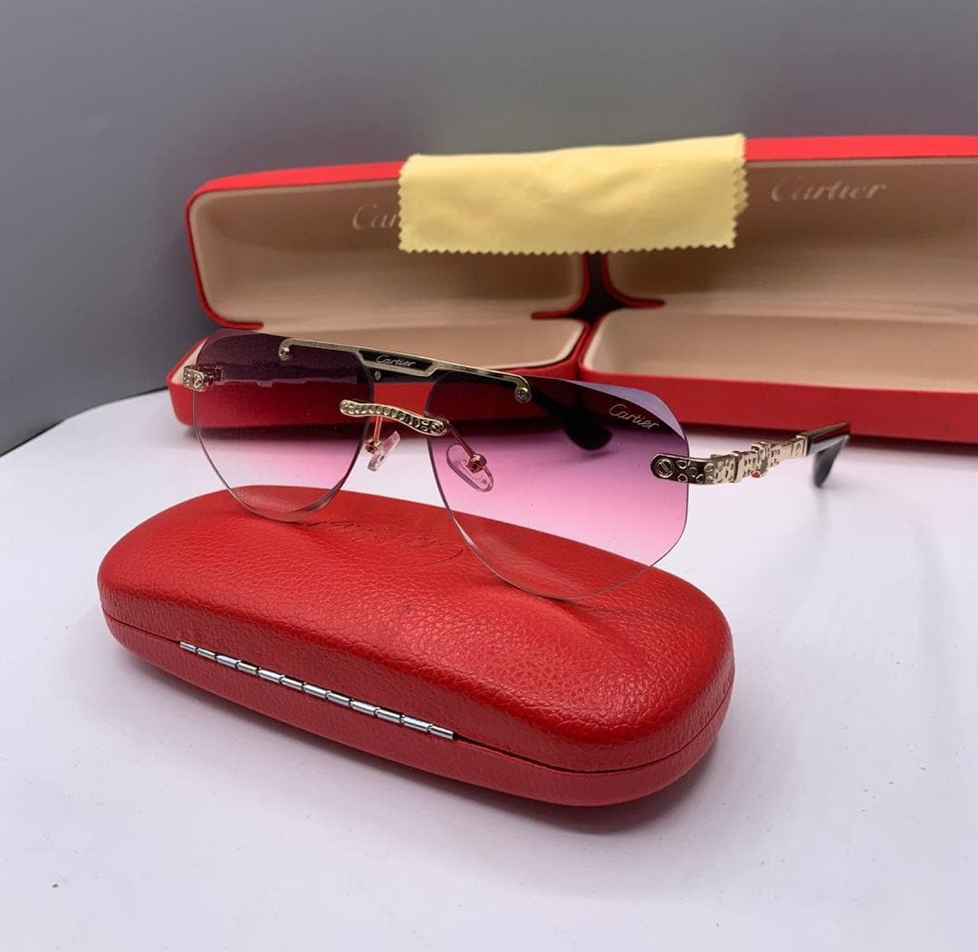 Cartier rimless sunglasses with pink gradient lenses on red case.