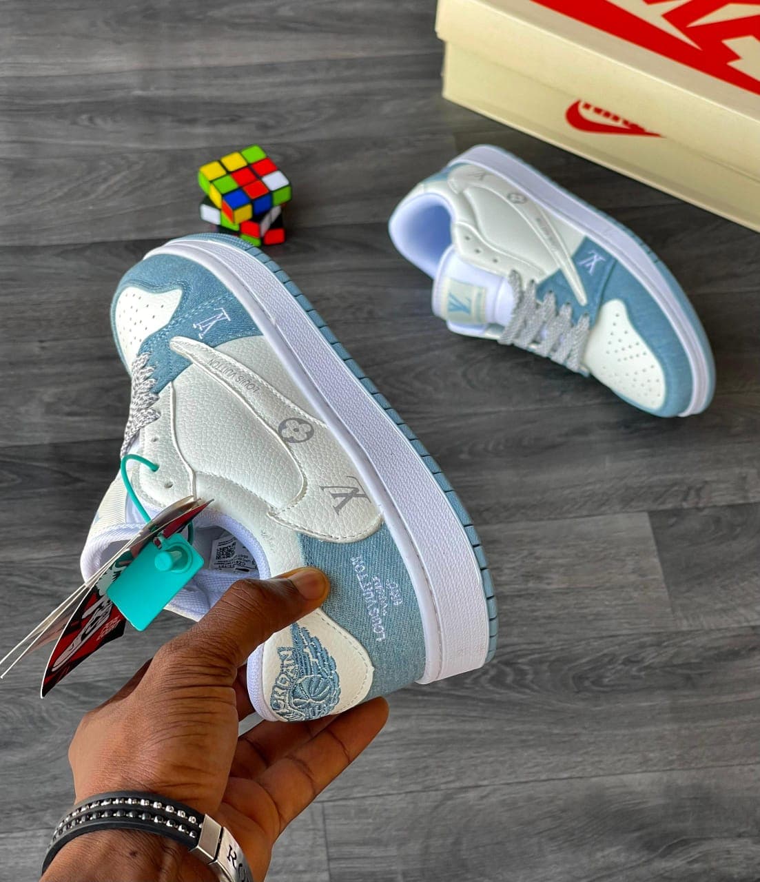 Close-up side view of Louis Vuitton x Nike sneaker showing monogram details and tags.