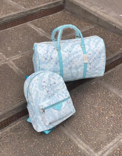 Light blue teddy print backpack and duffle bag set on outdoor steps.