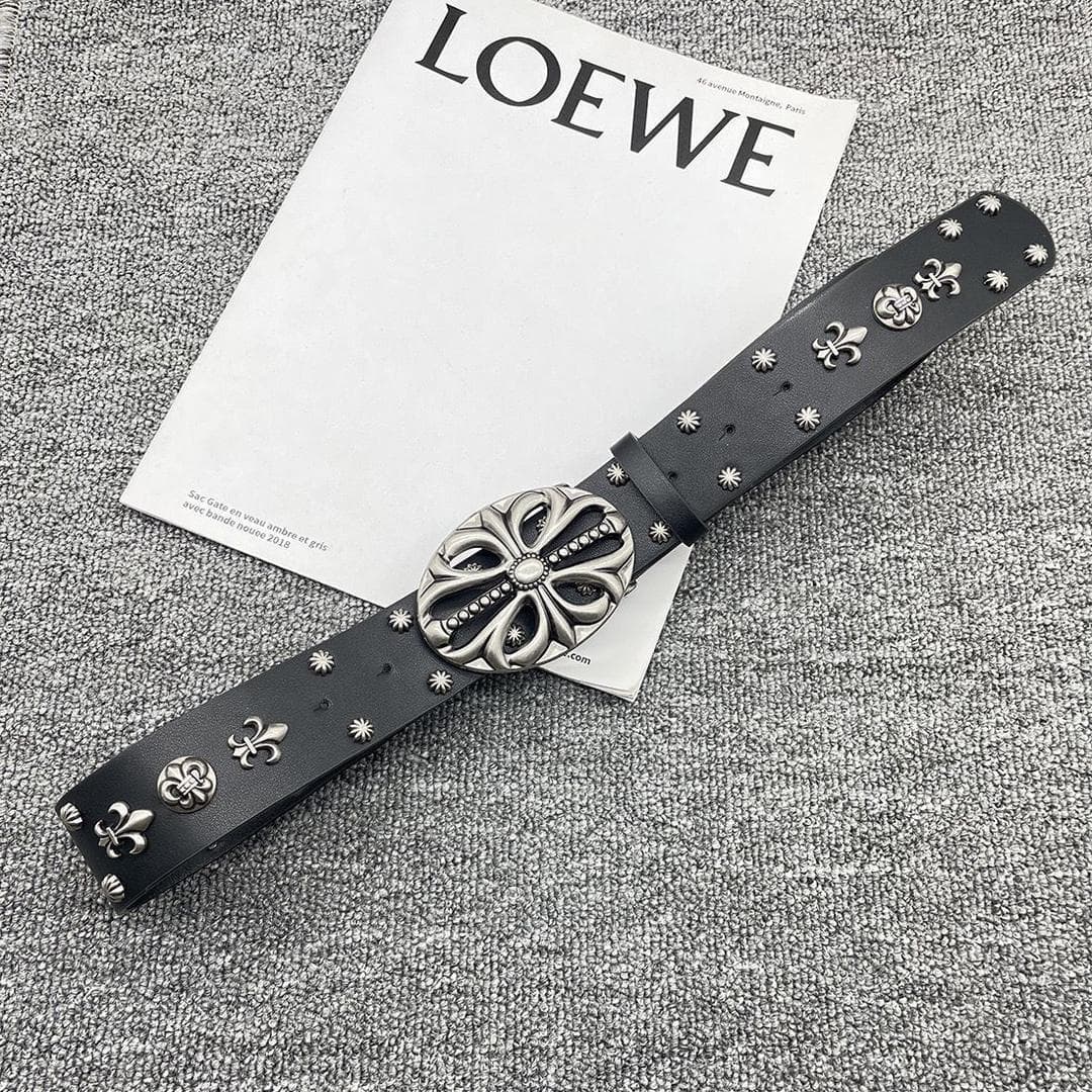 Black belt with silver fleur de lis and large ornate buckle on magazine.