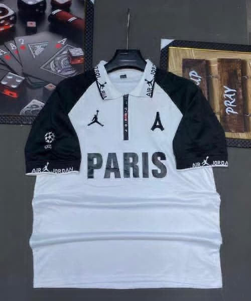 White and black PSG Jordan Paris football jersey on hanger with background props.