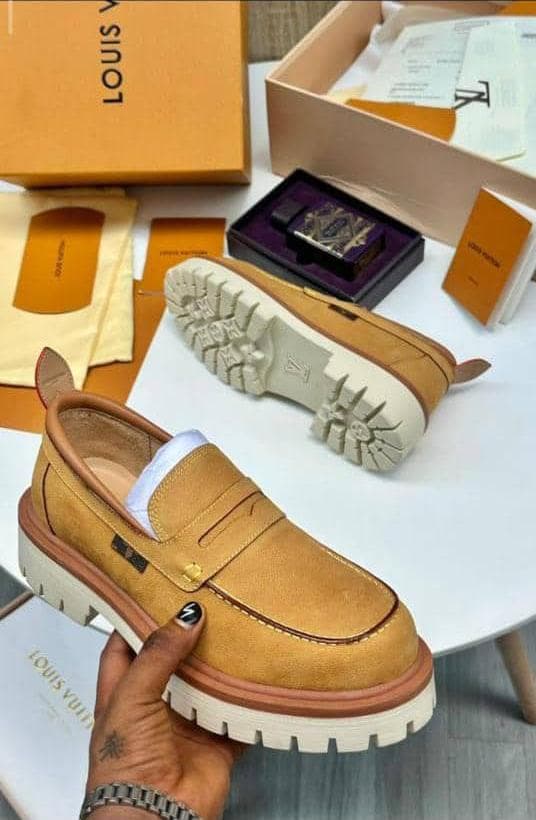 Tan Louis Vuitton suede loafers with white chunky sole held with luxury LV packaging and boxes.