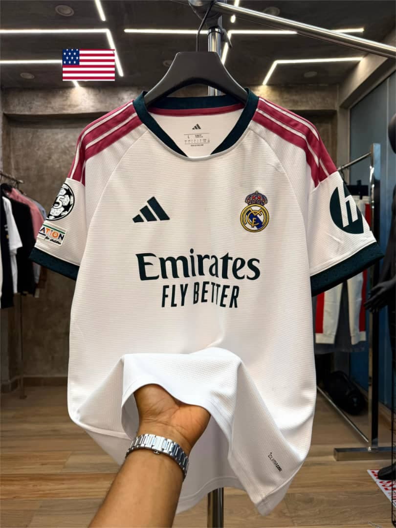 White Adidas Real Madrid jersey with colored stripes and sponsor text.