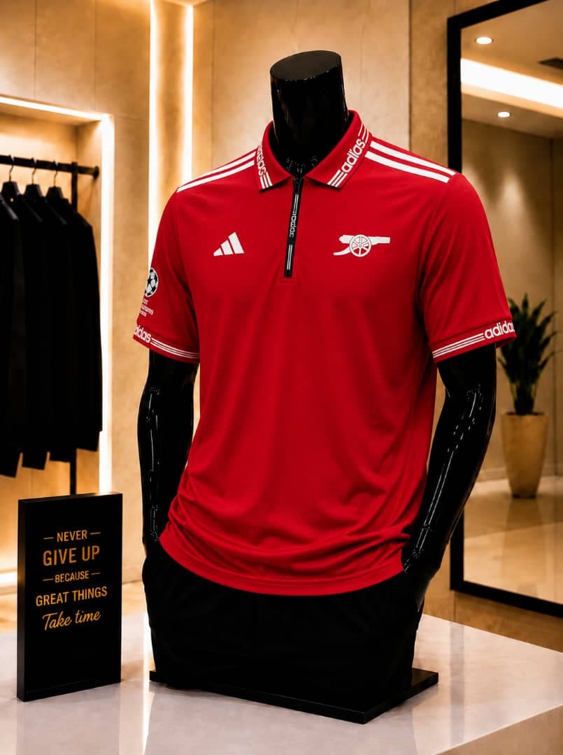 Red Arsenal Adidas polo jersey on mannequin.