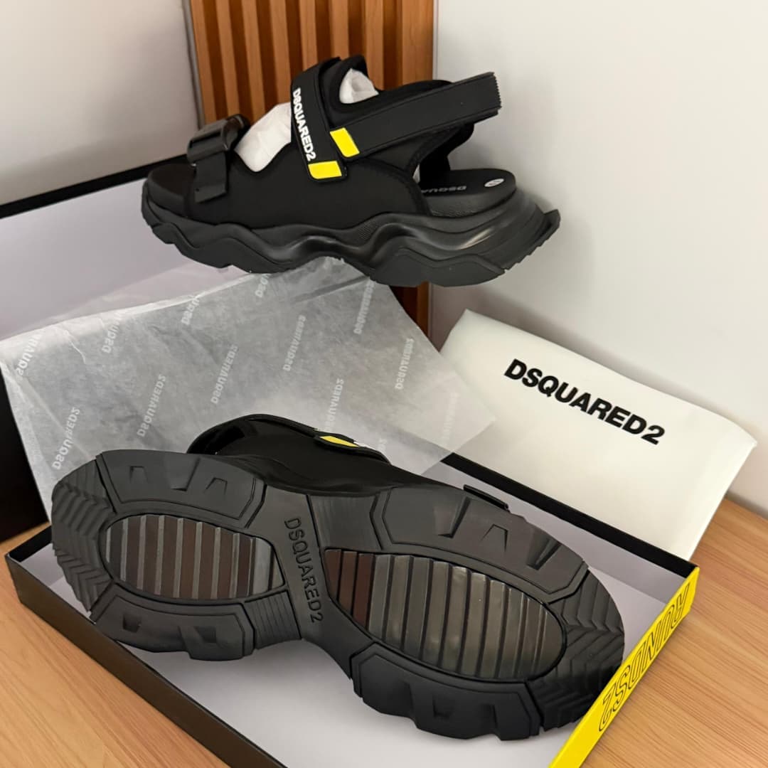 Black DSquared2 sandals with yellow details shown in box with branding paper.