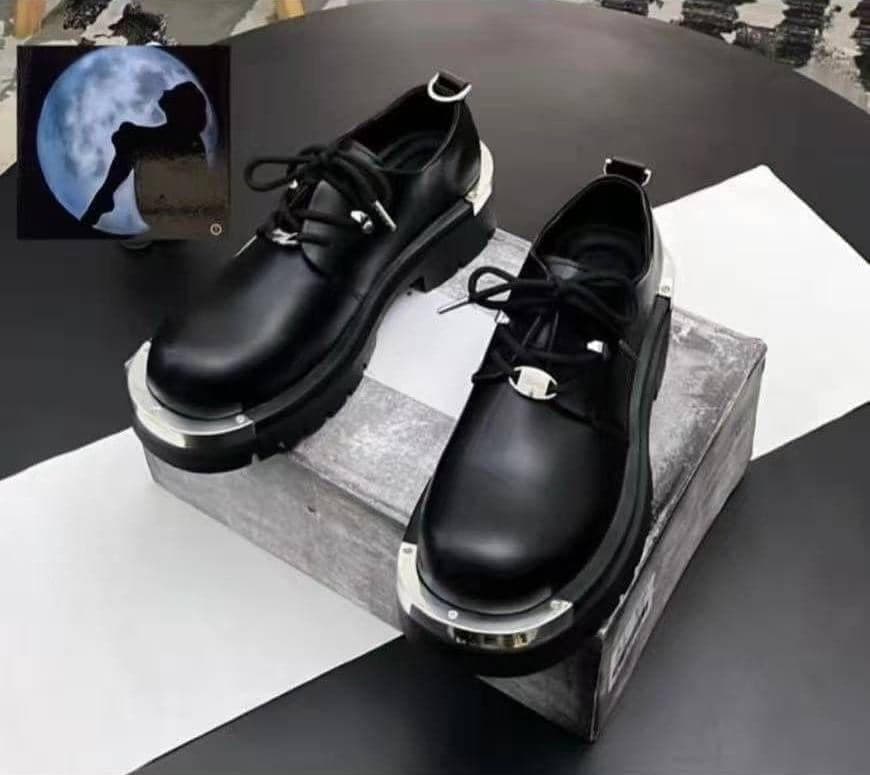 Black leather platform lace-up shoes with silver metal caps on display blocks.