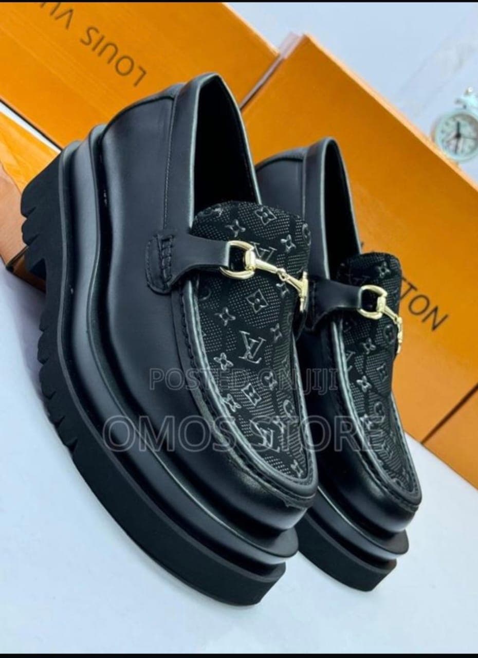 Black LV monogram platform loafers displayed with orange luxury boxes.