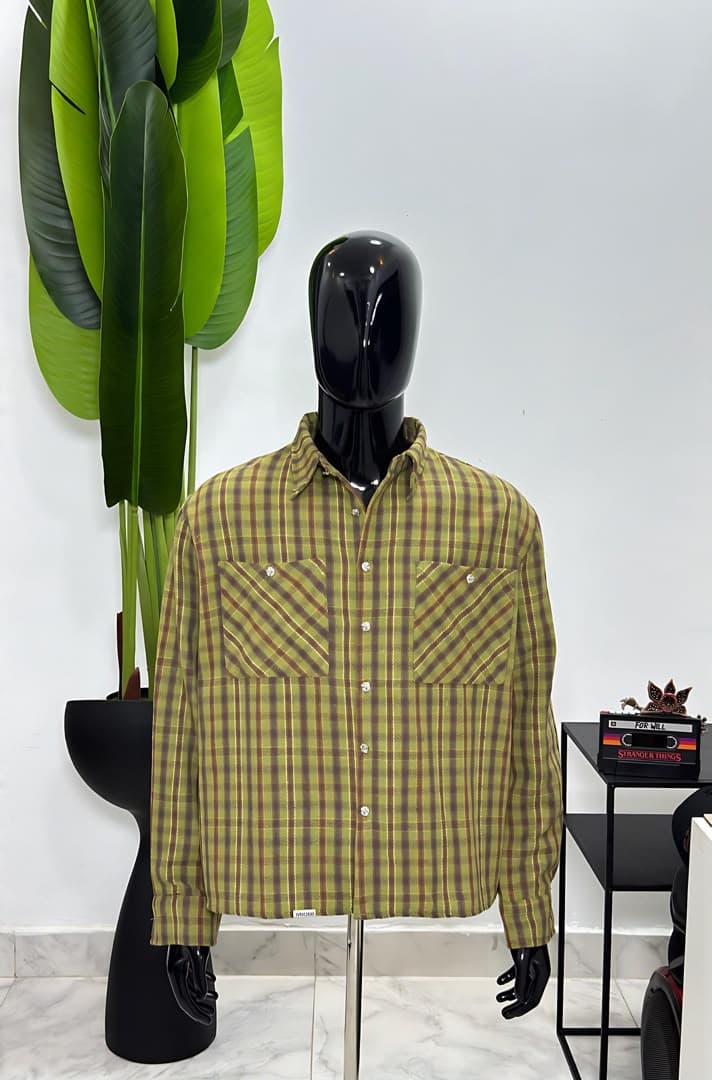 Mannequin wearing olive plaid long-sleeve button-up shirt jacket with chest pockets.