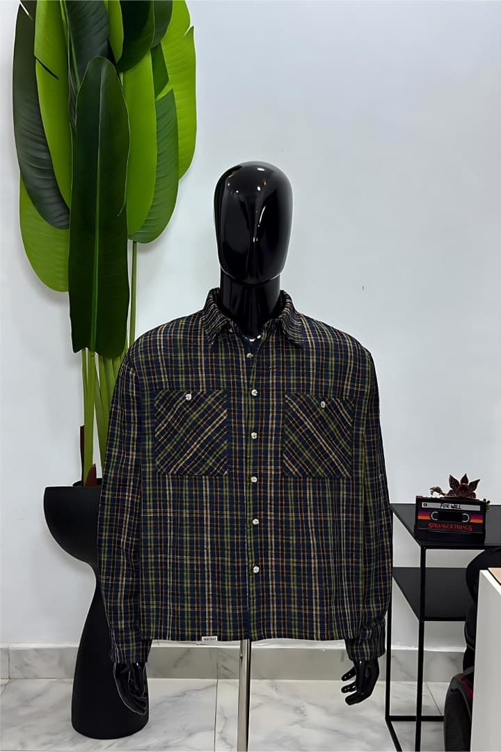 Mannequin wearing navy plaid long-sleeve button-up shirt jacket with chest pockets.