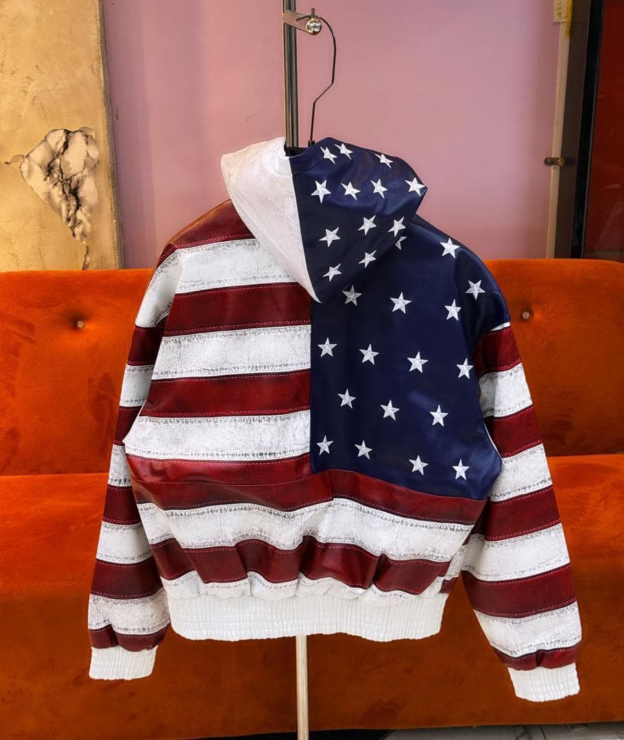 Back view of American flag hooded jacket on hanger displaying full stars and stripes pattern.