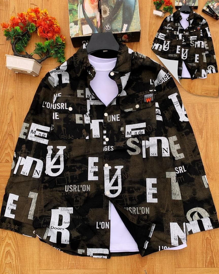 Black denim jacket with white typographic and text collage prints on wooden background.