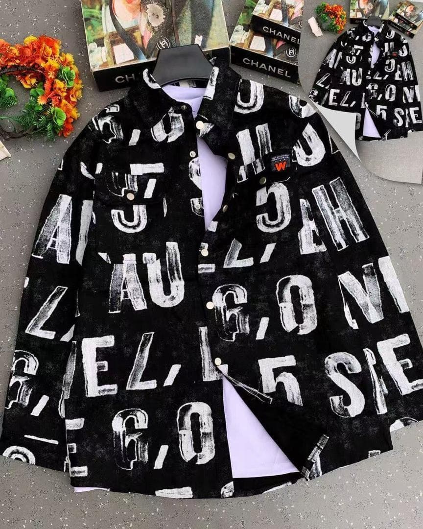 Black denim jacket with large white distressed letter prints displayed on hanger.