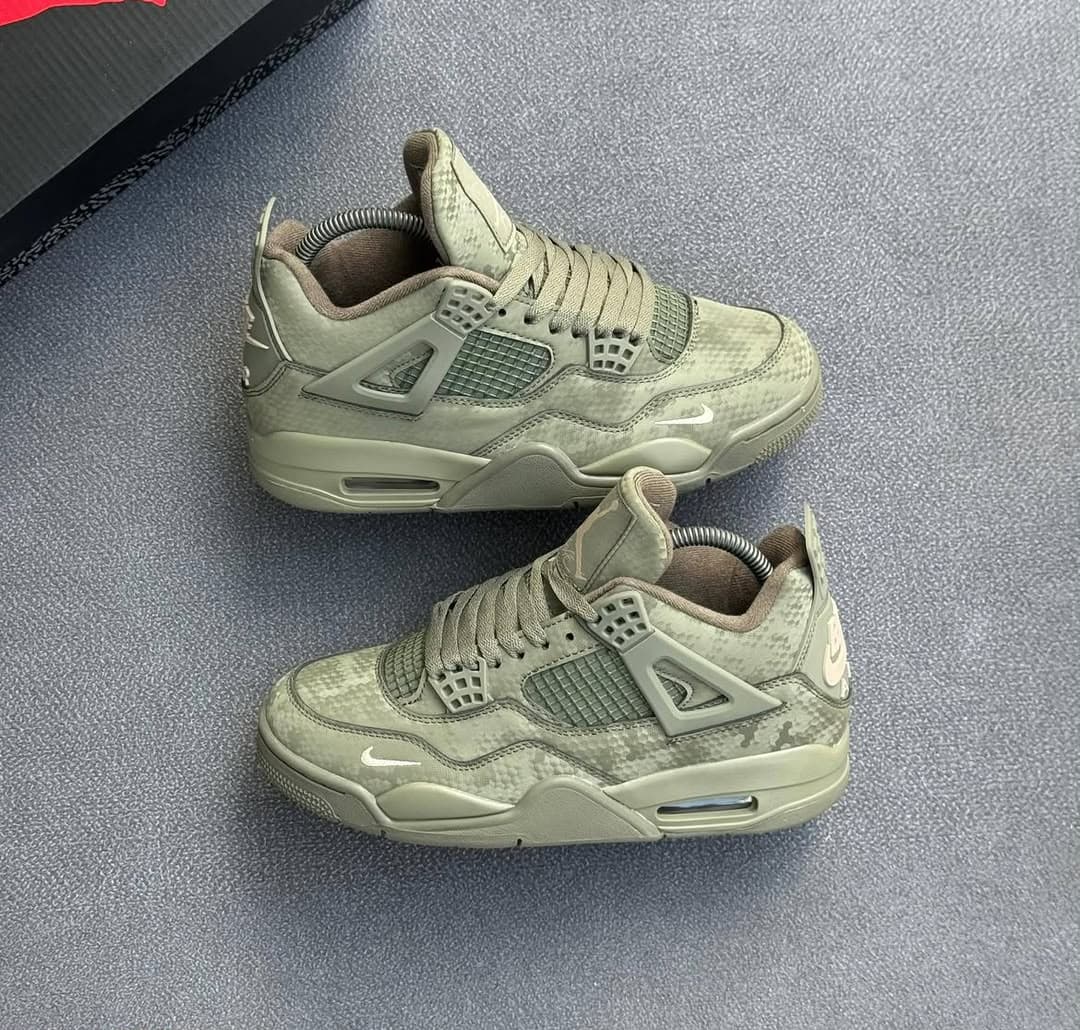 Pair of olive camo Air Jordan 4 sneakers on gray surface.