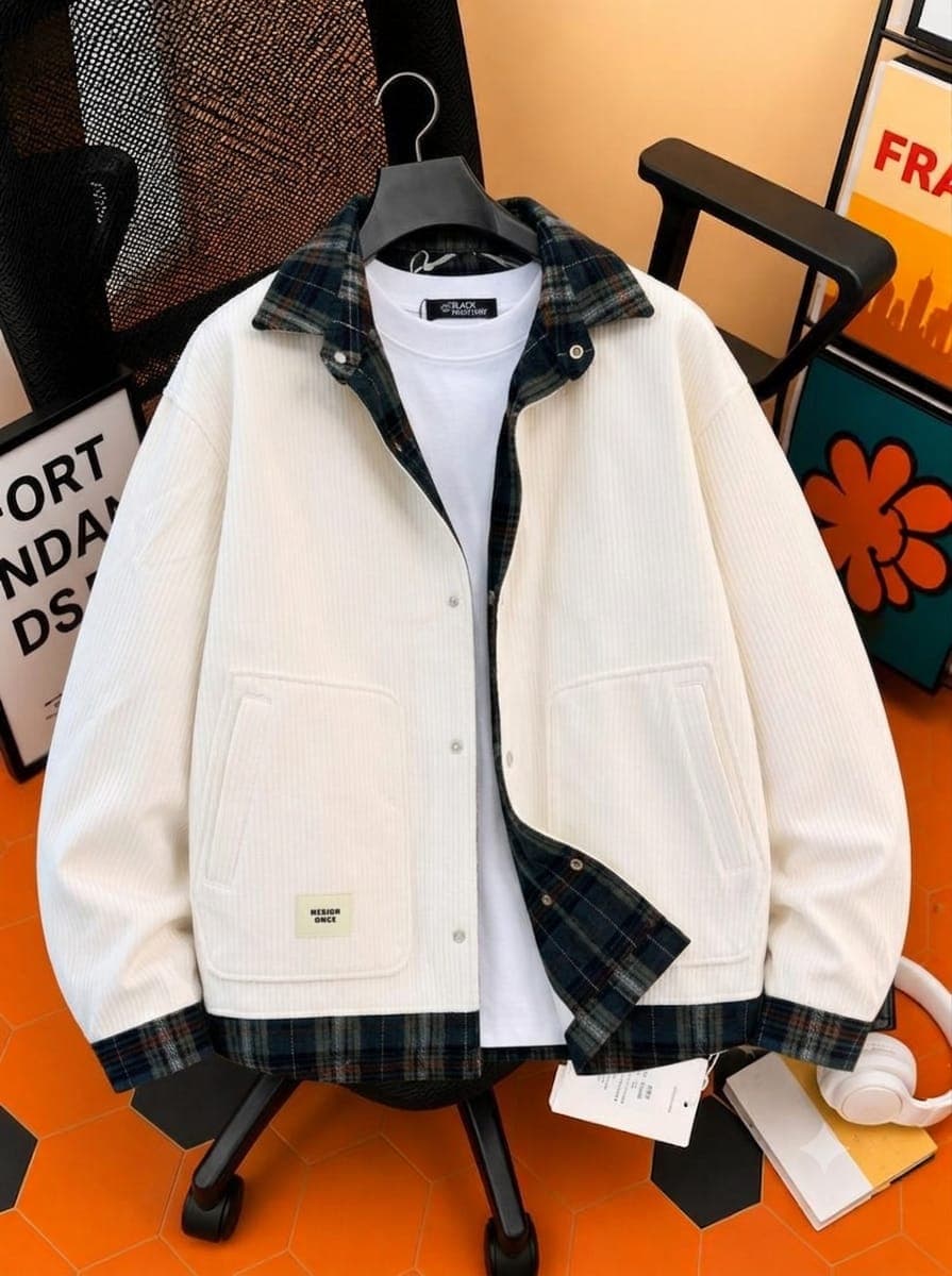 White corduroy jacket with plaid inner collar, lining and chest pockets over white t-shirt.