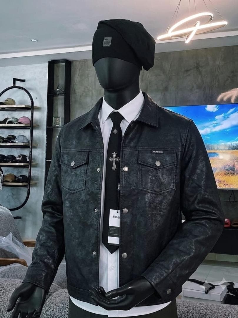 Mannequin in black washed leather trucker jacket with white shirt, black tie and beanie.