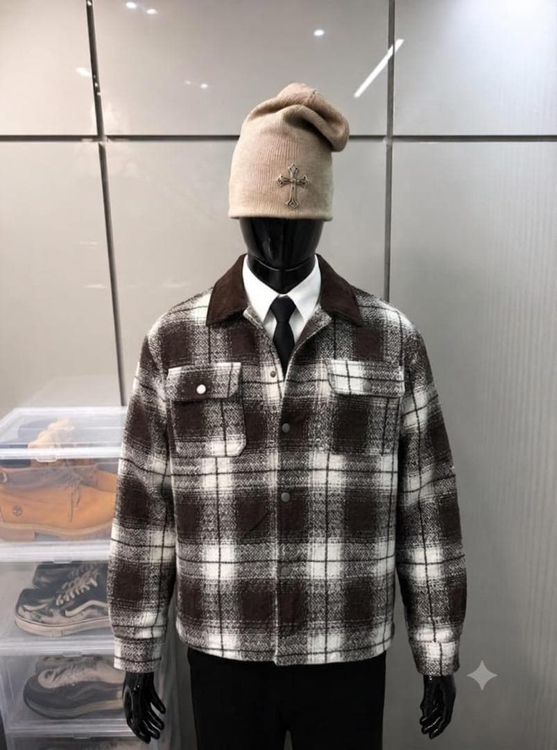 Mannequin wearing brown and white plaid flannel jacket with beige beanie, white shirt and black tie.