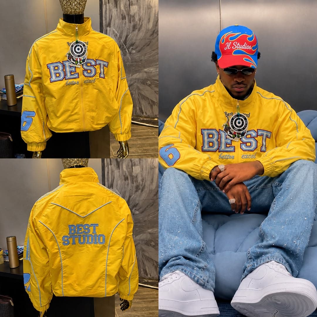 Yellow embroidered zip-up jacket with blue accents shown on mannequin front, back, and worn by model.