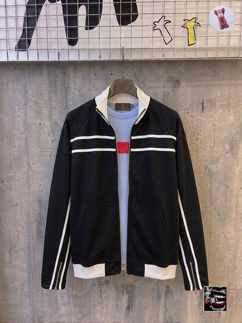 Black zip jacket with white stripes and blue t-shirt layered underneath.