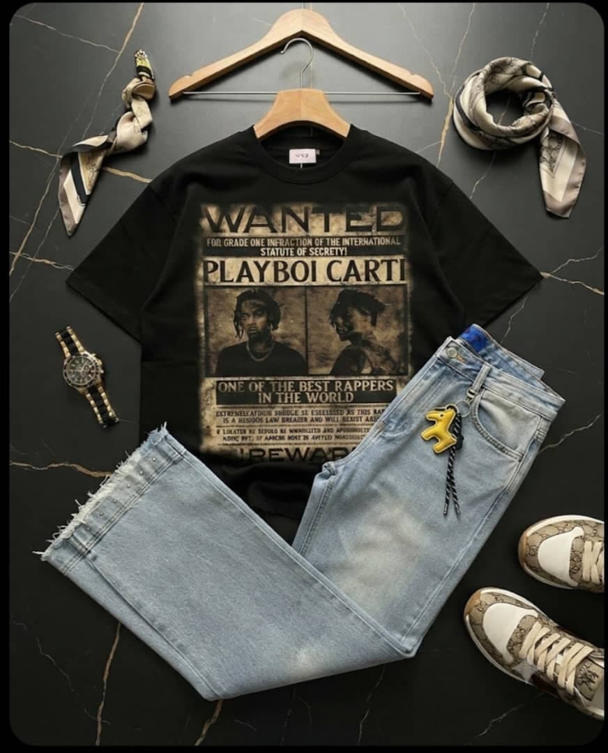 Black Playboi Carti wanted graphic t-shirt paired with light blue ripped jeans and accessories on dark marble.