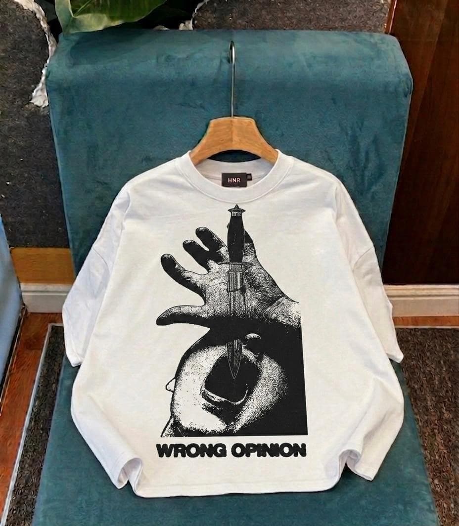 White crop tee with hand holding dagger graphic and WRONG OPINION text.