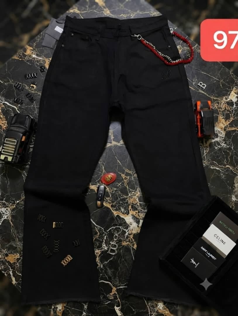 Black baggy jeans on marble background with chain red beads and branded cards.