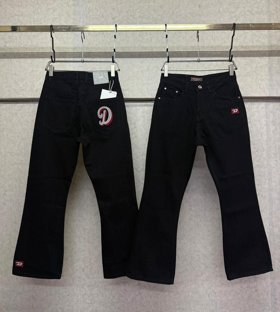 Two pairs of black flared jeans on hangers showing different D logo designs on back pockets.
