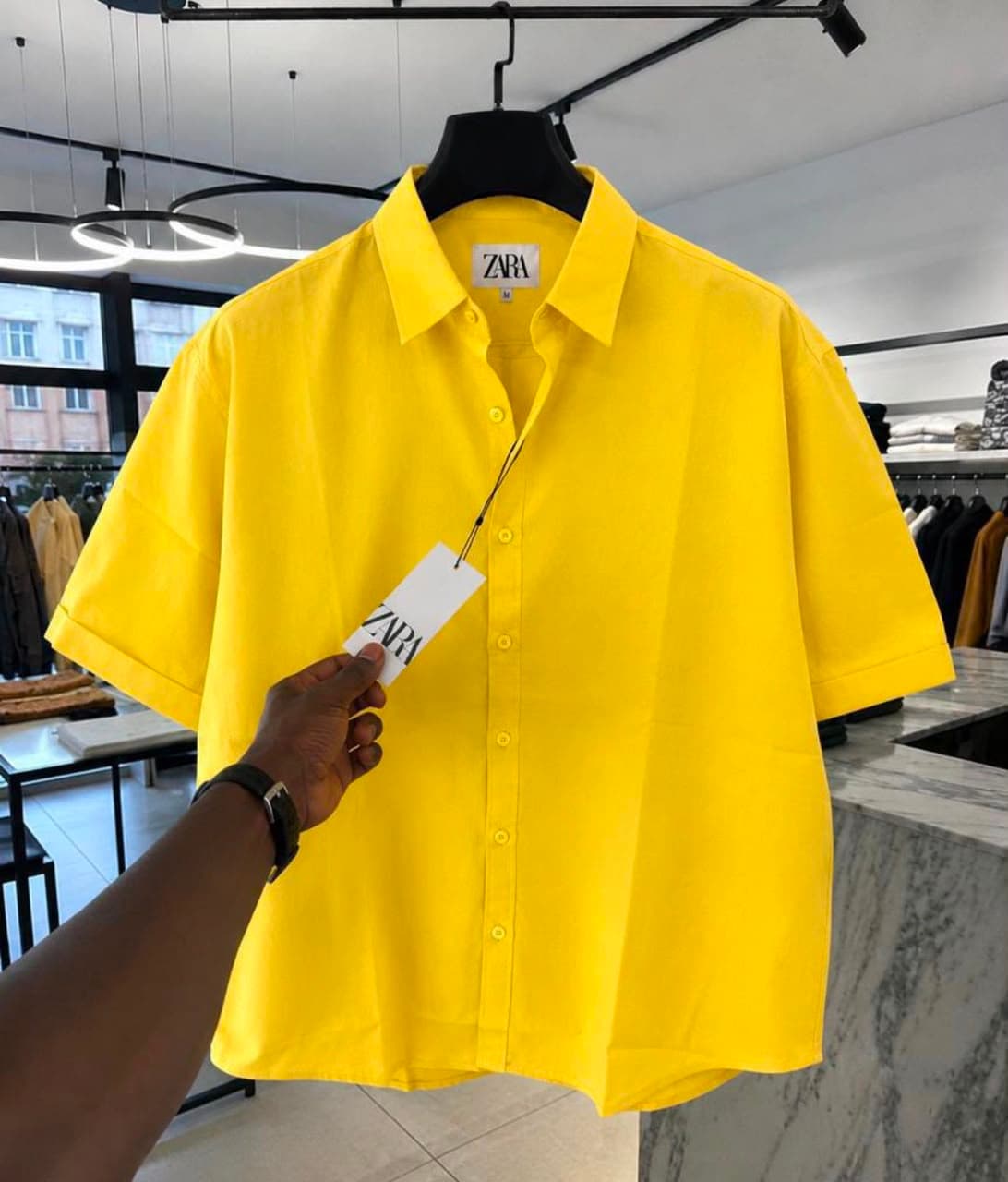 Yellow Zara short sleeve button-up shirt on hanger with tag.