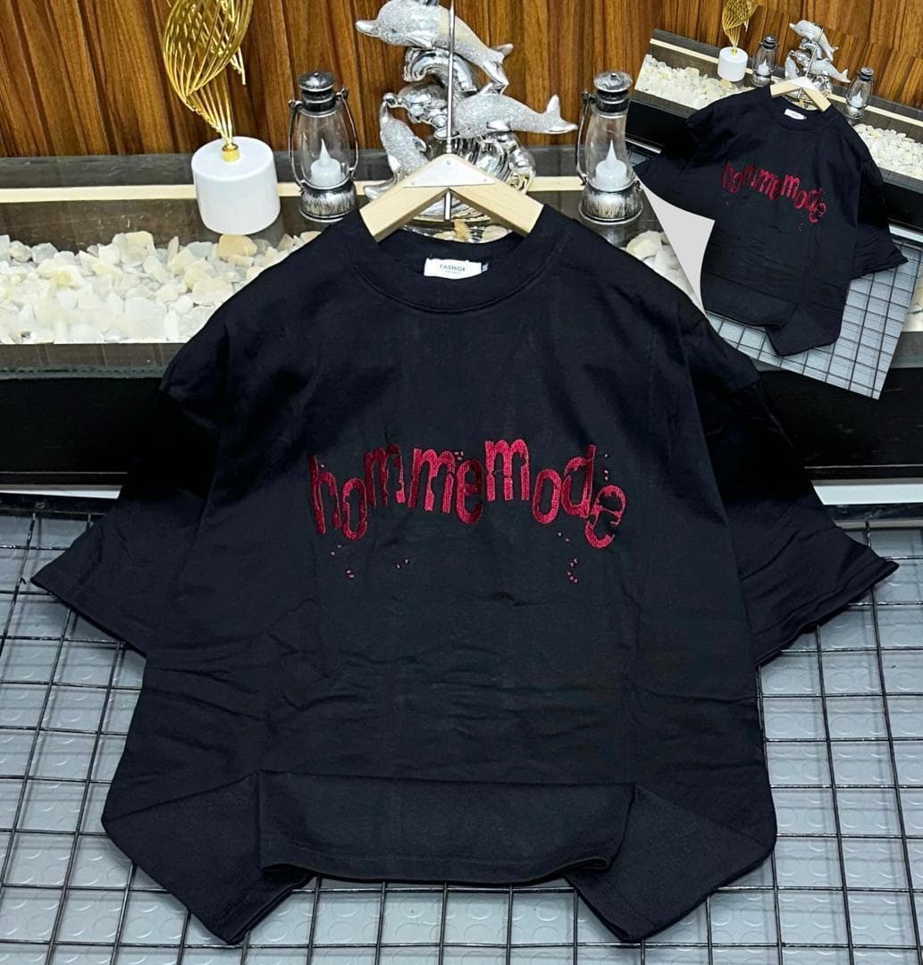 Black oversized t-shirt with red hommemode dripping glitter text print on grid background with inset.