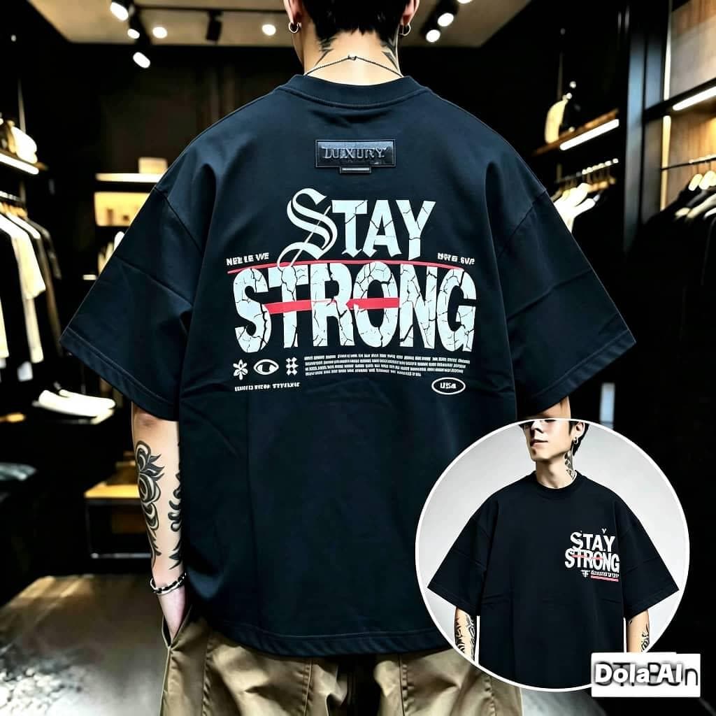 Man in black Stay Strong graphic oversized t-shirt showing back with large text and symbols, plus front inset.