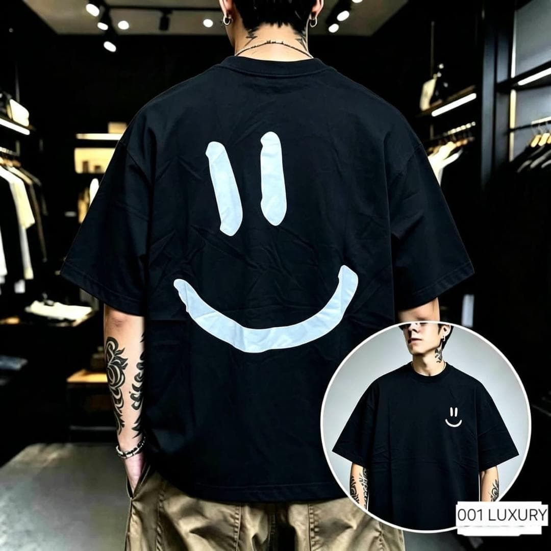 Back view of black oversized t-shirt with large white smiley face print and inset front with small smiley.