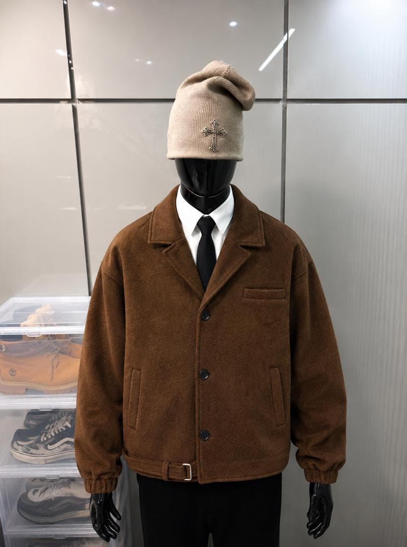 Brown wool button jacket on mannequin styled with shirt, tie, and beanie.