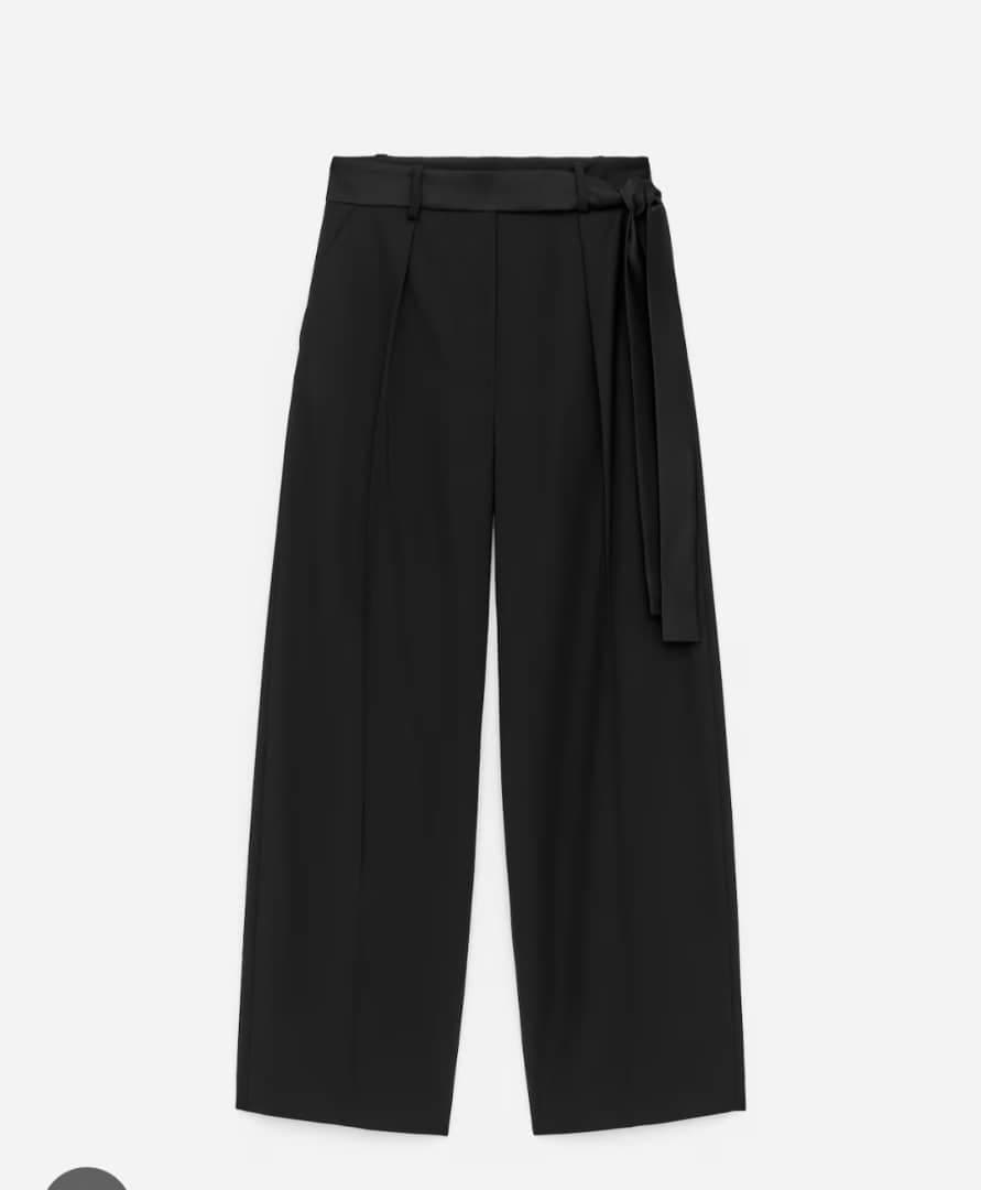 Black pleated wide-leg flare pants with self-tie belt against white background.
