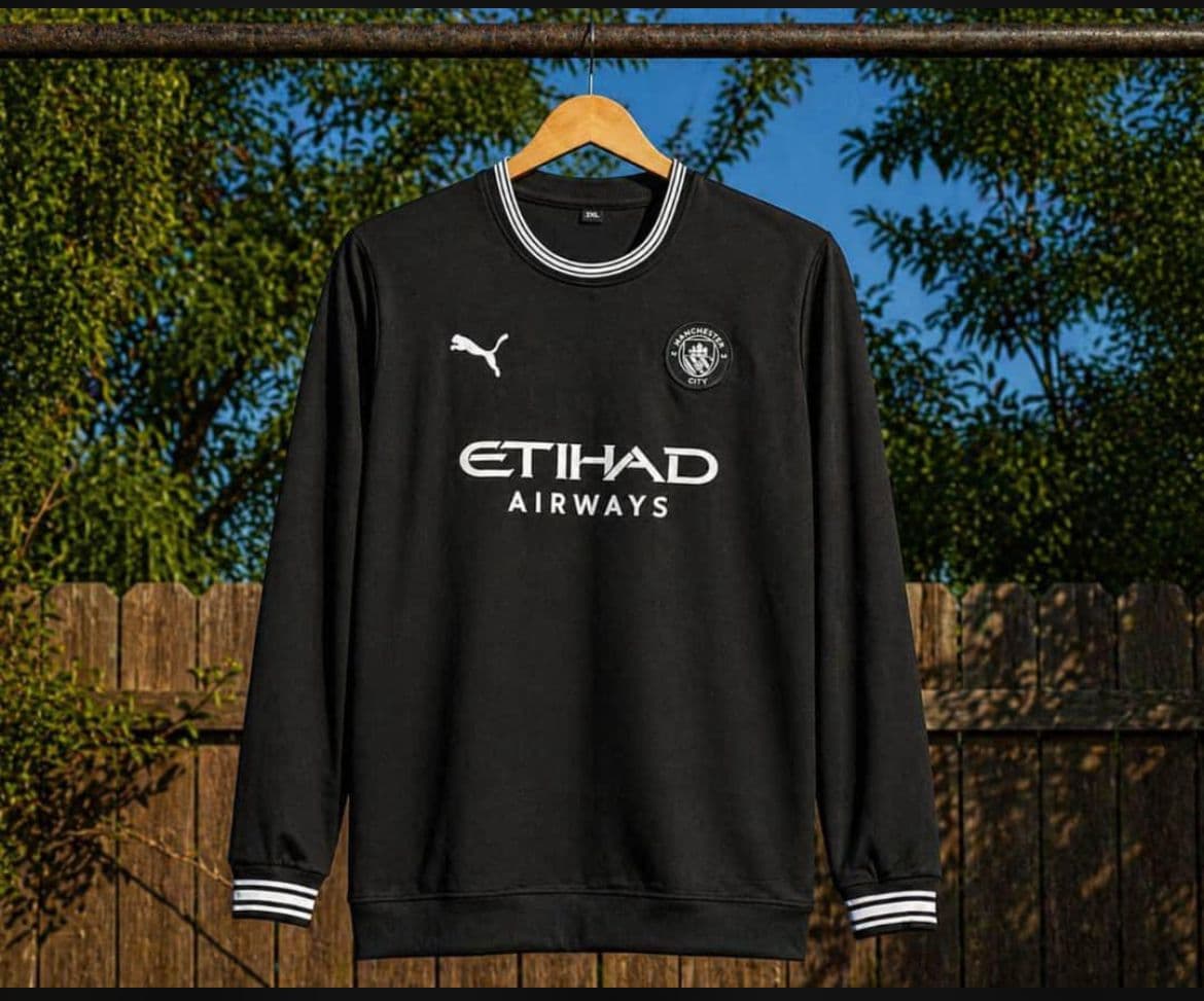 Black Manchester City long sleeve jersey with Etihad Airways print and white trim.