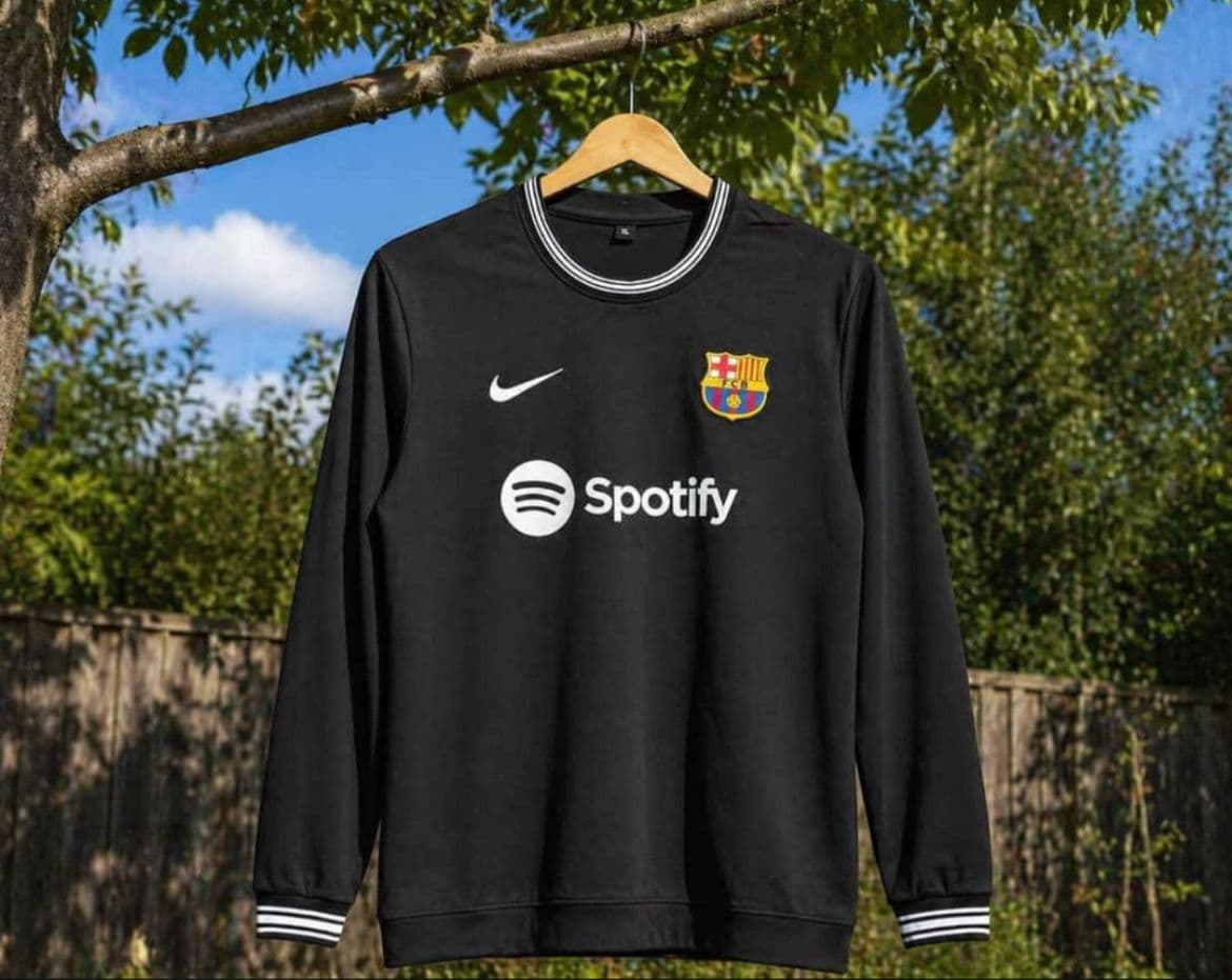Black Barcelona long sleeve jersey with Spotify logo and striped trim.