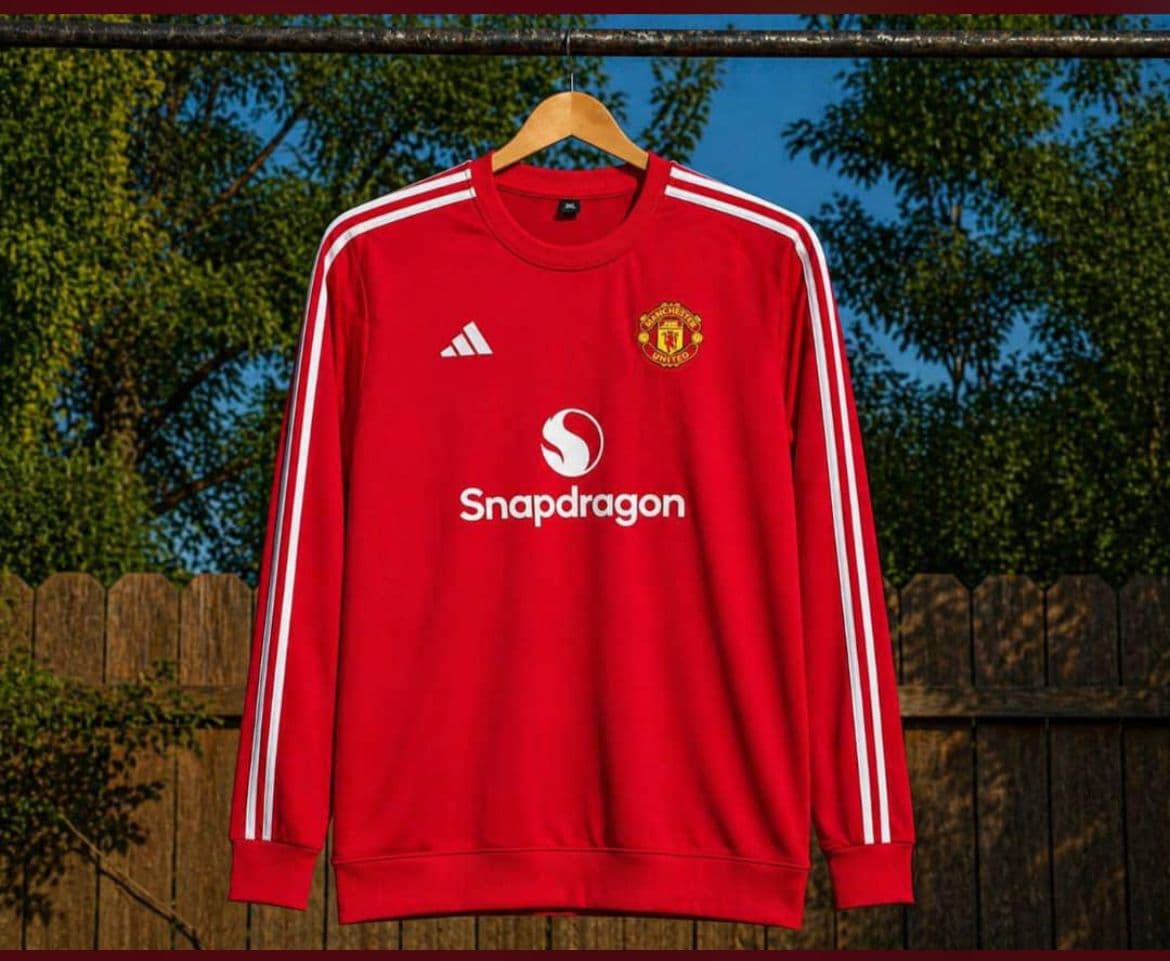 Red Manchester United long sleeve jersey with white stripes and Snapdragon sponsor.