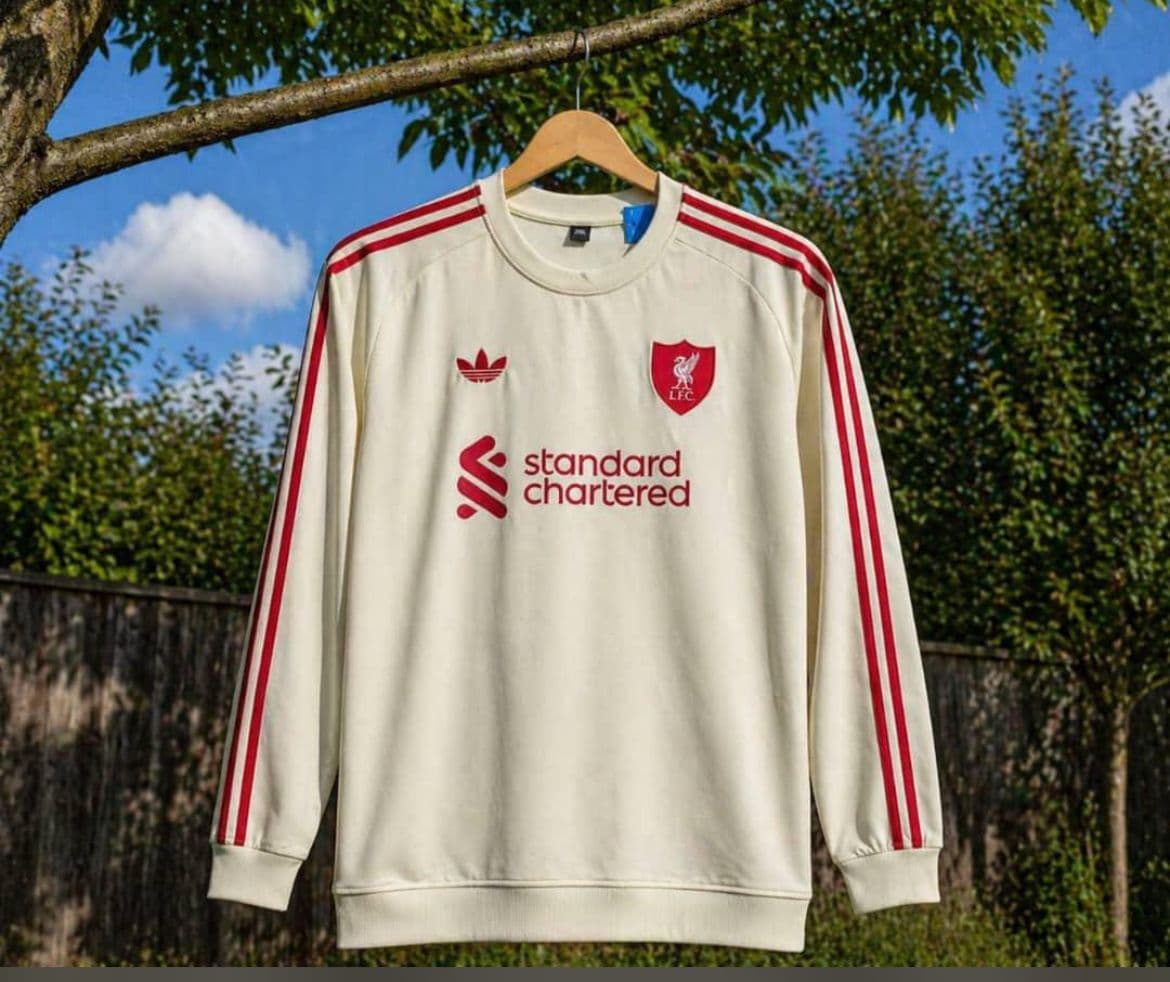 Cream Liverpool long sleeve jersey with red stripes and Standard Chartered sponsor.