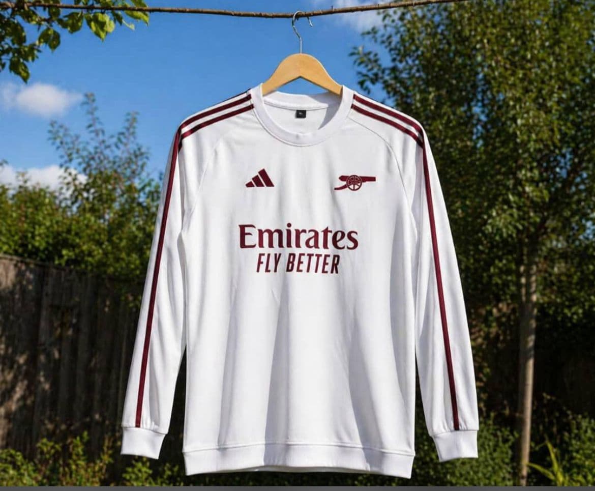 White Arsenal long sleeve jersey with maroon stripes and Emirates branding.