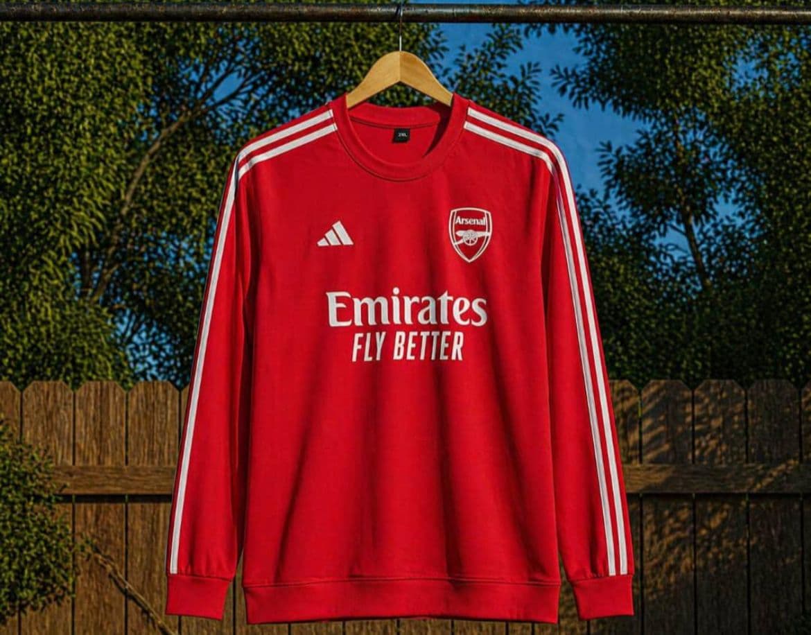 Red Arsenal long sleeve jersey with Emirates Fly Better sponsor and white sleeve stripes.