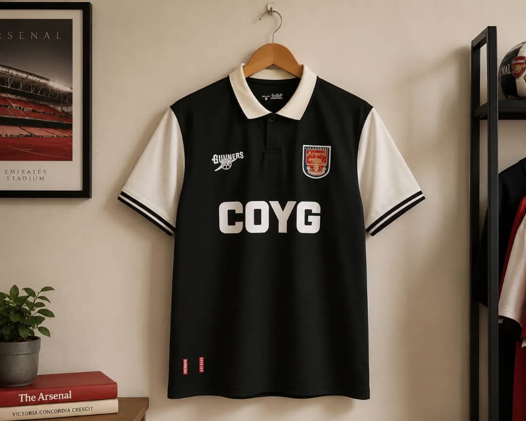 Arsenal COYG football jersey in black with white sleeves and collar.