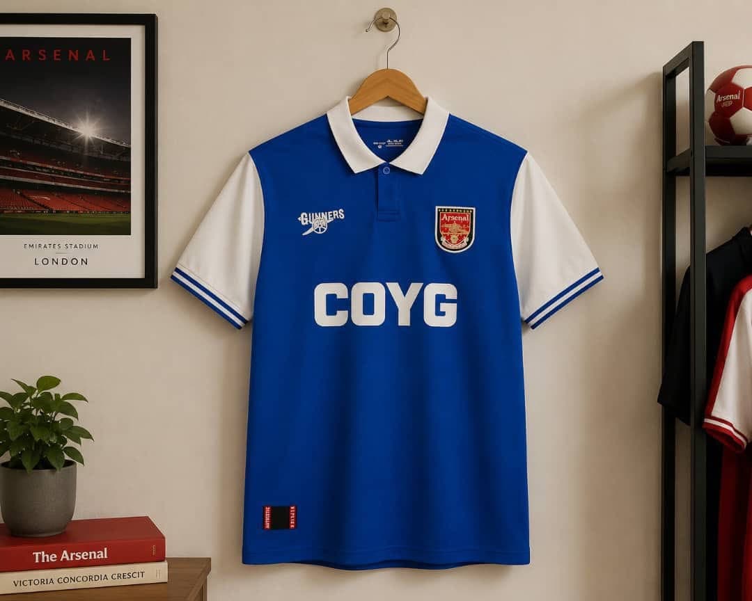 Arsenal COYG football jersey in blue with white sleeves and collar.