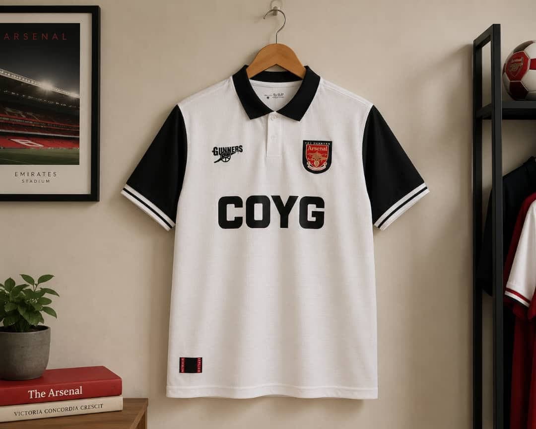 Arsenal COYG football jersey in white with black sleeves and collar.