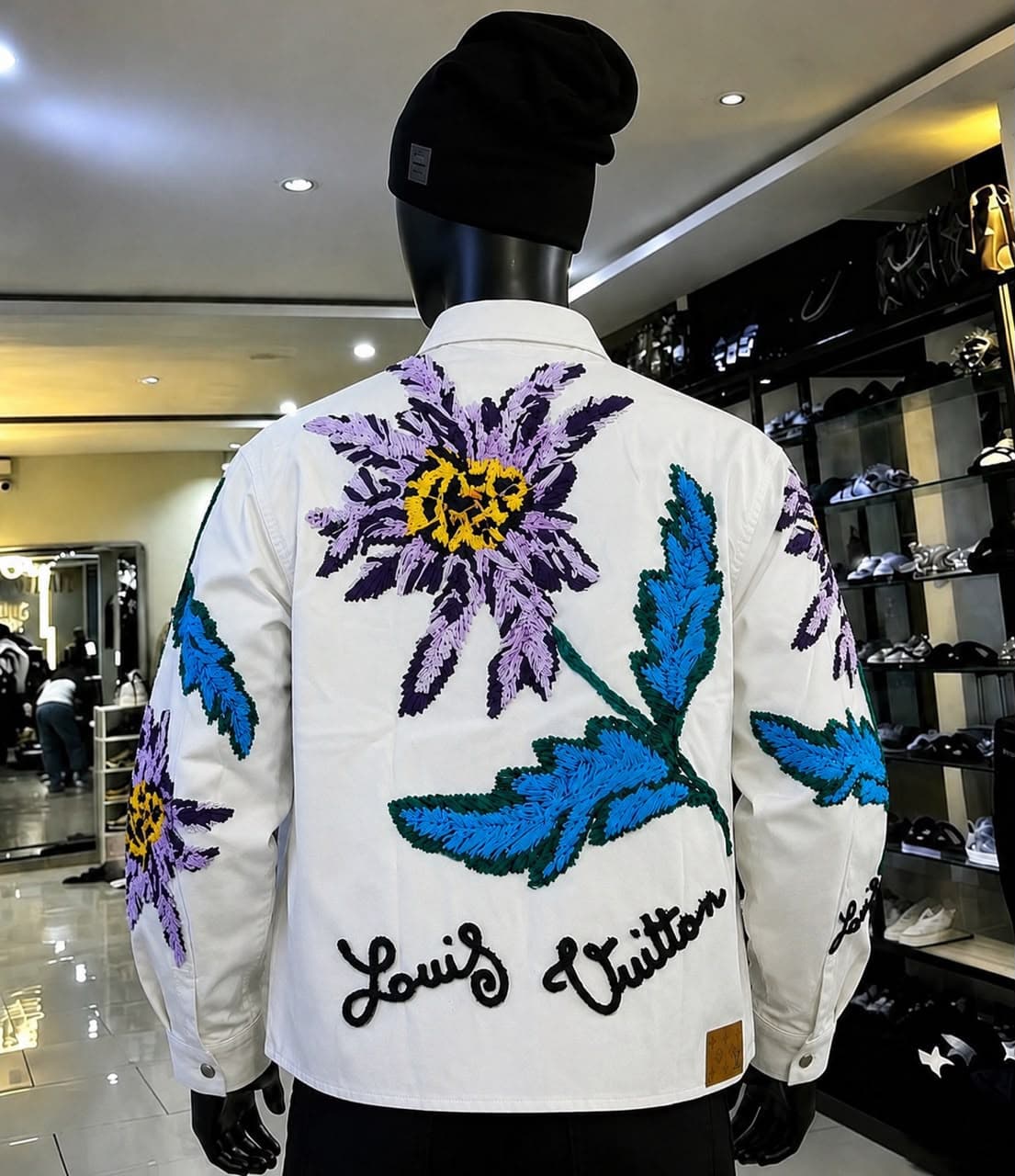 Back view of white floral embroidered Louis Vuitton jacket on mannequin.