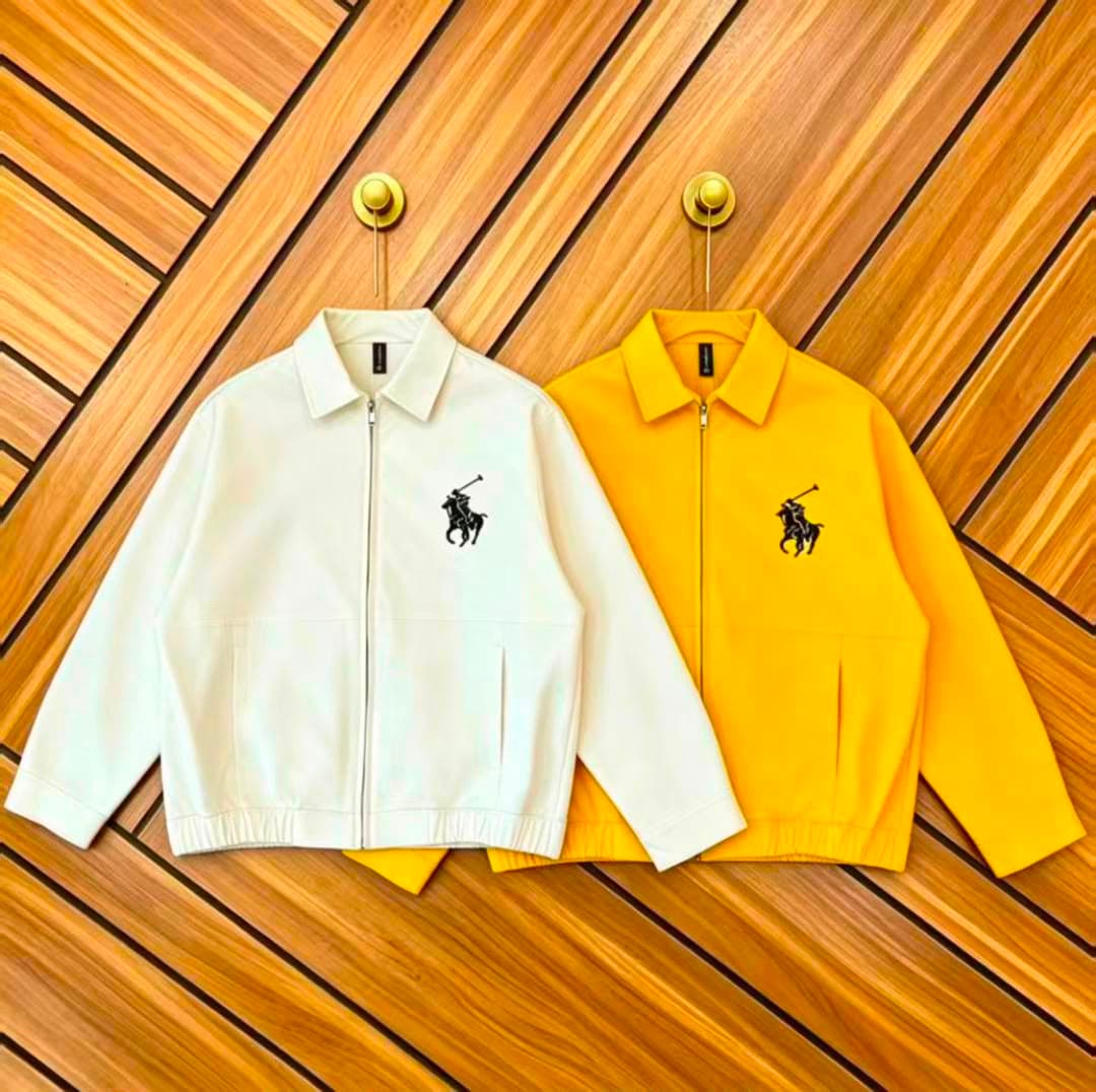 White and yellow zip-up jackets with polo logo on wooden background.