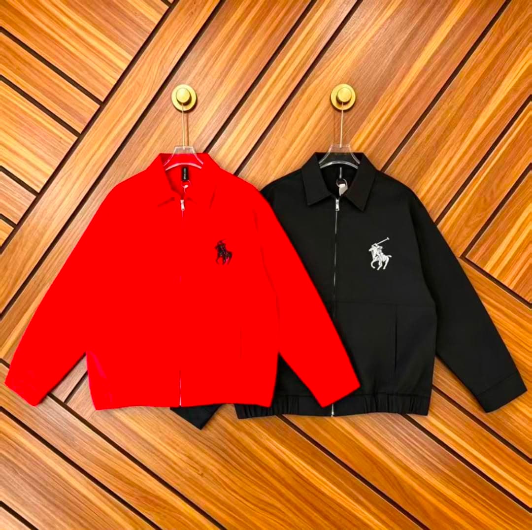 Red and black zip-up jackets with polo logo on wooden wall.