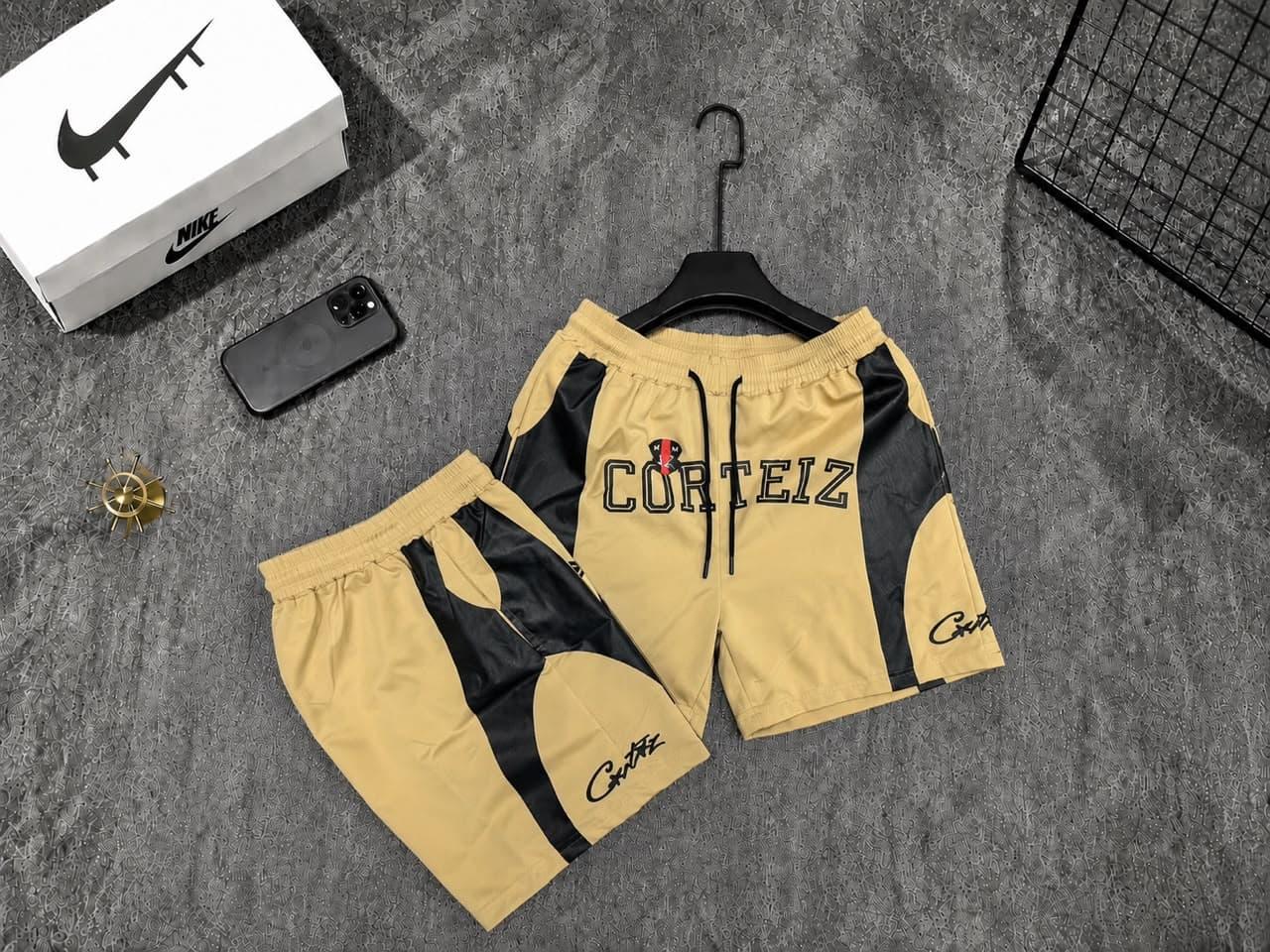 Yellow Corteiz logo shorts with black panels.