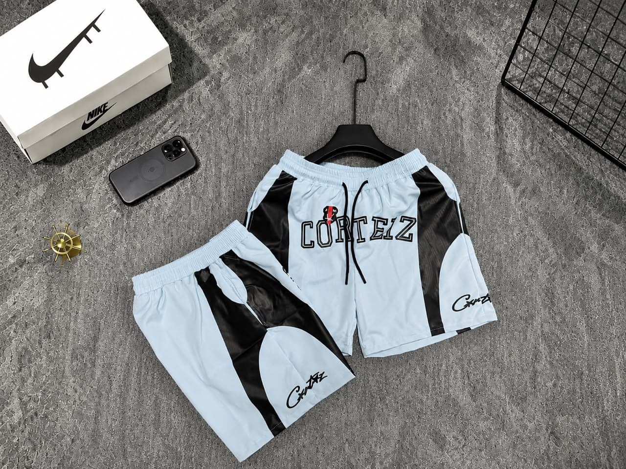 Light blue Corteiz logo shorts with black panels.