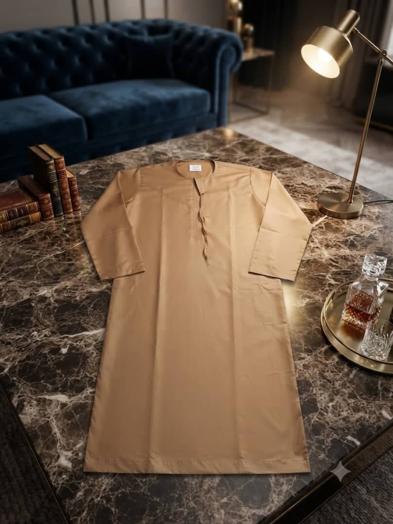 Tan plain long sleeve jalabia on marble table.