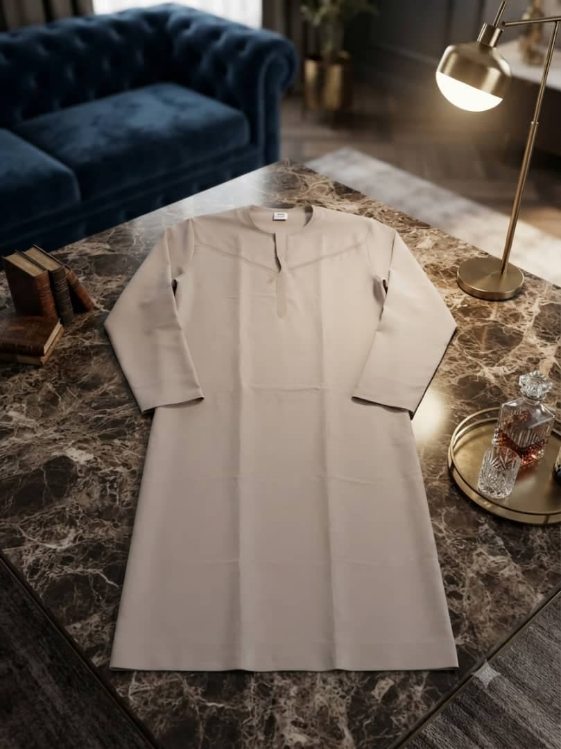 Beige plain long sleeve jalabia on marble table.